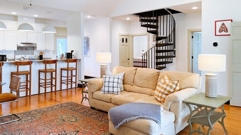 The great room has a big comfy couch and two lounge chairs, all facing the 55in smart tv, which displays works of art when turned off.