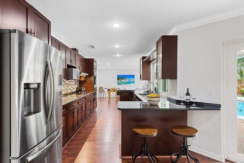 Prepare a family meal in the fully-equipped kitchen offering bar seating, updated appliances and pool views.