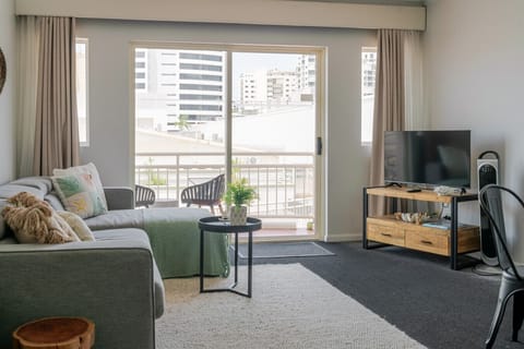 Comfortable living space with sofa bed, Smart TV, and access to balcony views