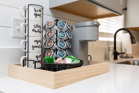 Coffee bar in kitchen with coffee, decaf coffee, sugar, creamer, and green tea.