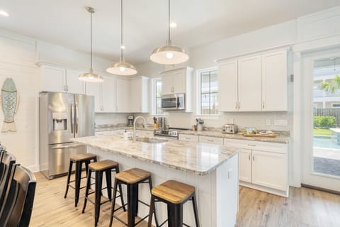 Modern kitchen with a huge fridge and stainless steel appliances.