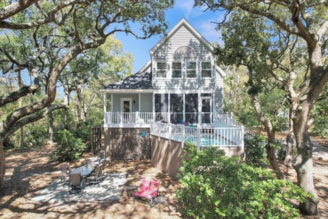 Charming beach house nestled under a canopy of oaks, featuring a private plunge pool, screened porch, and serene island setting
