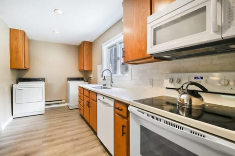The laundry area is made up of a washer and dryer and is situated just adjacent to the kitchen, straight from the entrance to the home. Natural light and lovely views brighten the space thanks to the over-the-sink window.