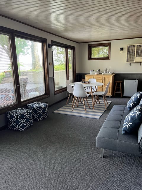 Downstairs three season room with futon couch and beverage fridge