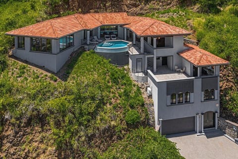 Villa Sueño Moderno (Modern Dream Villa) is a 4-story home built into the hills of Coco Bay Estates.  The home features an elevator or you can get your steps in and use the stairs!  
The 1st level is the main entry and garage. 
The 2nd level is a large studio apartment.  
The 3rd level features a full laundry room, gas BBQ and outdoor kitchen.
The 4th level has an infinity pool...