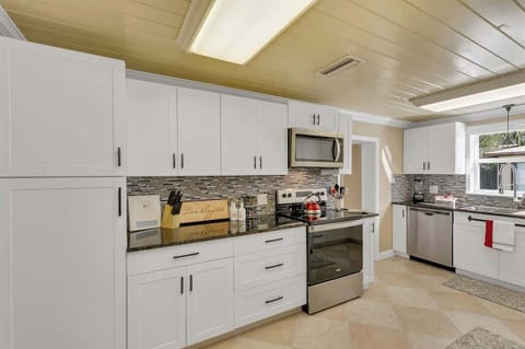 Open, clean & beautiful kitchen stocked with everything you should need: pots, pans, plates, bowls, glasses, cups, utensils, wine glasses, coffee mugs, tea kettle, Keurig Duo k-cup/coffee maker, k-cups, coffee, creamer, sugar blender, spice rack, etc