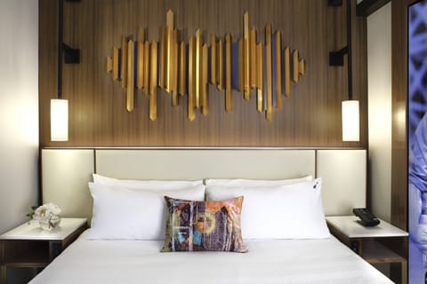 Sink into crisp linens beneath striking modern headboard art.