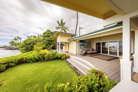 Spacious covered lanai with lush green lawn and tropical landscaping