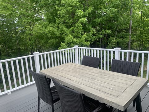 Back deck with table, chairs, and a bench. Wonderful for morning coffee/meals