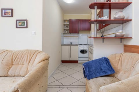 Living room corner with a comfortable armchair and decorative shelves.
