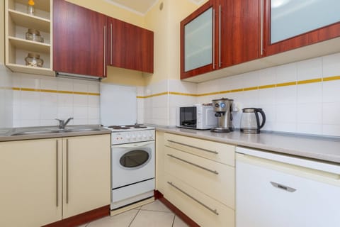 Fully equipped kitchen with white cabinetry, a stove, and wooden accents.

