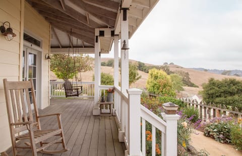 Front porch has a swing and rocking chairs with views of the valley and SF Bay.