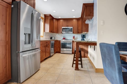 Fully equipped kitchen with French door refrigerator and stainless steel appliances