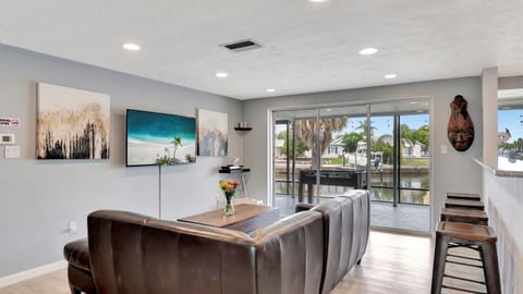 The floor-to-ceiling windows showcase an incredible view of the tranquil water canal.