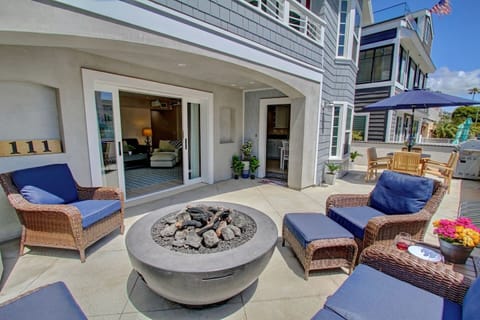 This is the downstairs unit. The patio has a fire feature, a loveseat, chairs, and end tables. On the other side of the patio, you have a dining table BBQ, and a hose to rinse off the sand. The picture shows the area that is included with the unit.