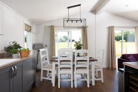 A dining table and chairs for all guests to eat together or play games - Forget Me Not Lodge