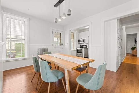 Dining Room with Seating for 6 and a bonus high chair amenity. Looks into kitchen with access to side porch entry