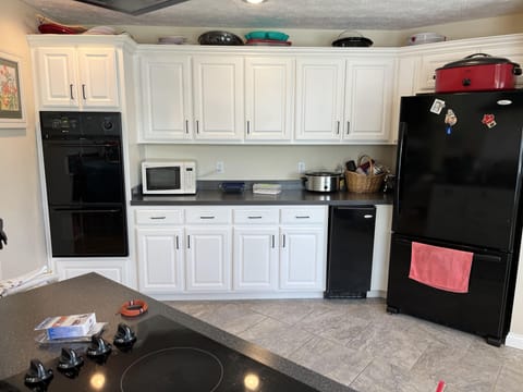 Kitchen view of double over, cabinets and refrigerator.