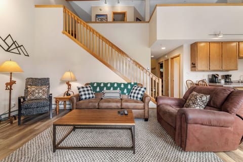 Living area featuring hardwood floors, vaulted ceiling, flat screen TV, gas fireplace and access to the private balcony.