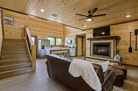 Spacious cabin living room with fireplace and warm wood interiors