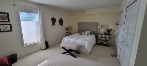 bedroom  with Queen bed, 2 night tables and a bench (1)