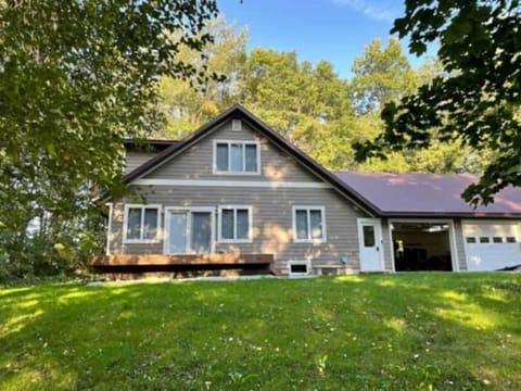 Front of house deck, driveway, 2 car garage .