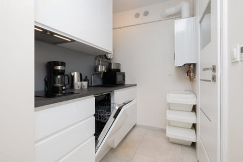 Kitchen angle focusing on the coffee machine and modern cabinets. 