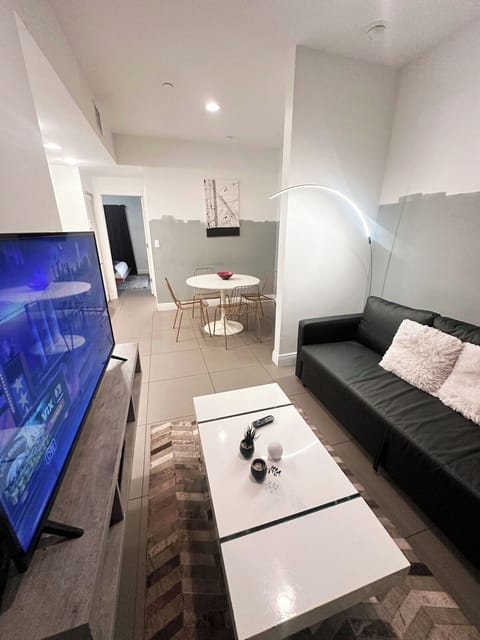 Living Room with a pull out couch and a Smart TV. The dining room to the back. 