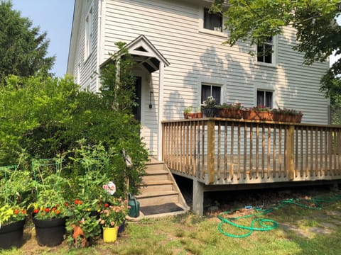 the back deck with beautiful views of the yard and mature trees, back entrance