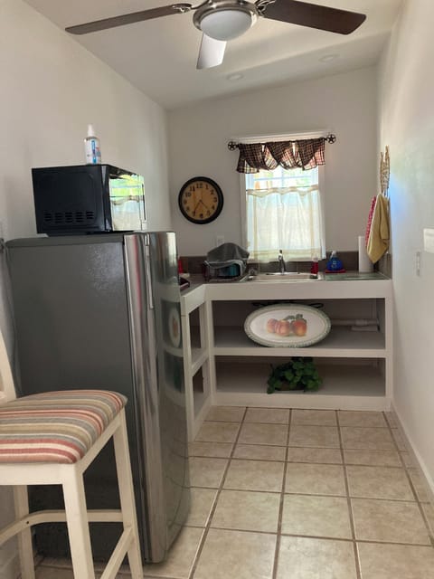 Mid size fridge, microwave, dishes, trash can & sink in kitchenette. NO STOVE. 
