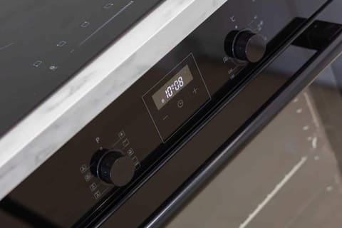 A close-up of a black oven with modern controls and a glossy finish, blending functionality with stylish design.
