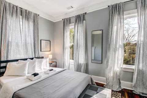 The first of two private bedrooms has a queen bed, ROKU TV, and a desk.