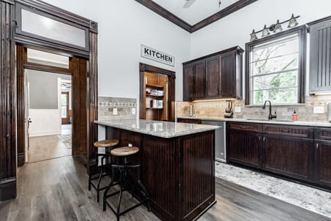 Kitchen with plenty of dishes, large fridge, an island, and pantry.