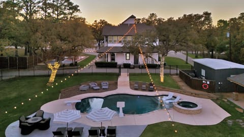 Arial view of the backyard and pool at dusk.