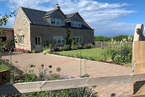 Goose Cottage - pretty cottage exterior with beautiful garden and blue skies