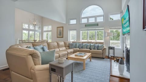 This inviting living area features soaring ceilings, abundant natural light, and a comfortable, open layout designed for gathering.
