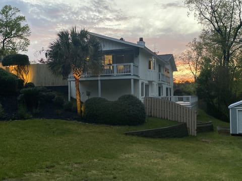 Right side view of the property shows the bedroom balconies and wraparound deck.