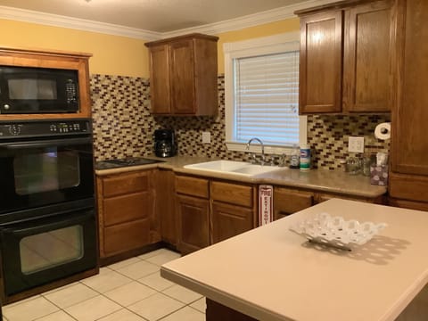 Modern kitchen with amenities: gas stovetop, toaster, coffee pot, and kettle