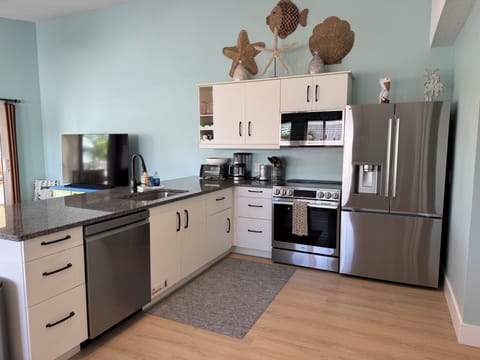 Fully stocked kitchen with new stainless steel appliances.