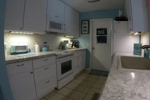 Galley kitchen fully equipped to have a home-cooked meal with your family