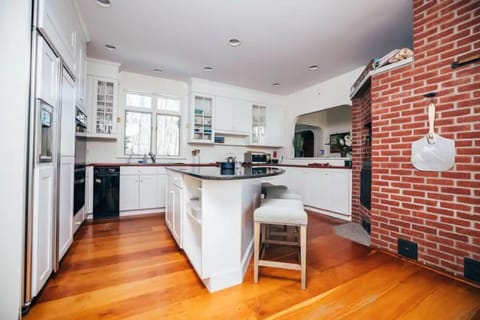 Spacious open island kitchen with masonry stove stainless steel cooktop 