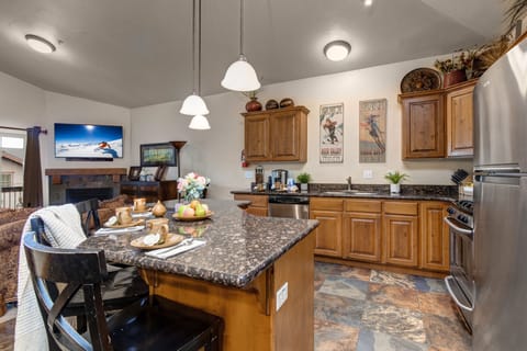 Fully Equipped Kitchen with stone countertops, stainless steel appliances, and island seating for three