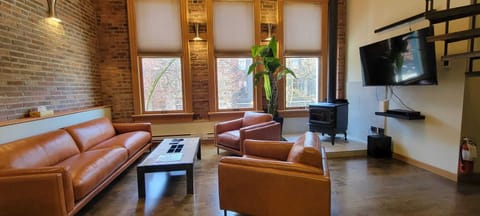 Leather couch in living room with wood burning stove