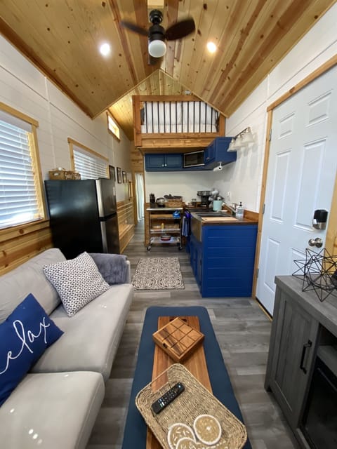Efficiency meets charm in this tiny home's living room and kitchen—a cozy space designed for big memories