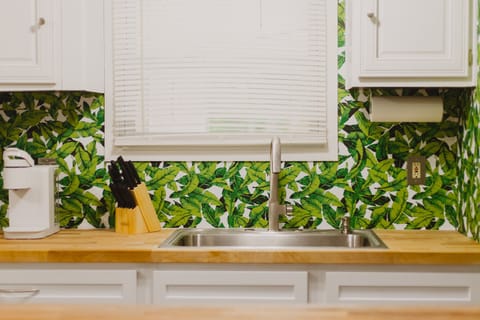 New butcher block counter top and with a large basin sink.