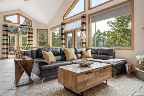 Main floor living room with a cozy sectional, Smart TV, gas-lit fireplace and walkout access to the private balcony.