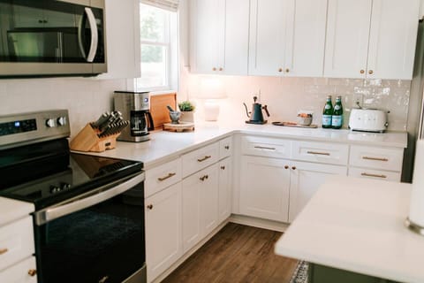 The luxurious kitchen is complete with stainless steel appliances and an island with seating for three, perfect for socializing with friends and family while creating delicious meals.