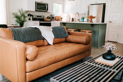 The stylish living room features a comfy sofa, a large HDTV with premium cable, a record player, and an assortment of books, making it the perfect room to gather with your group and enjoy some quality time together.