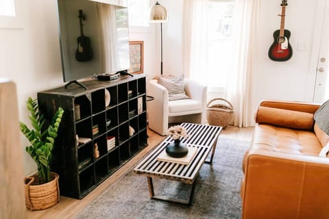 The stylish living room features a comfy sofa, a large HDTV with premium cable, a record player, and an assortment of books, making it the perfect room to gather with your group and enjoy some quality time together.