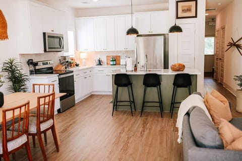 The luxurious kitchen is complete with stainless steel appliances and an island with seating for three, perfect for socializing with friends and family while creating delicious meals. 
